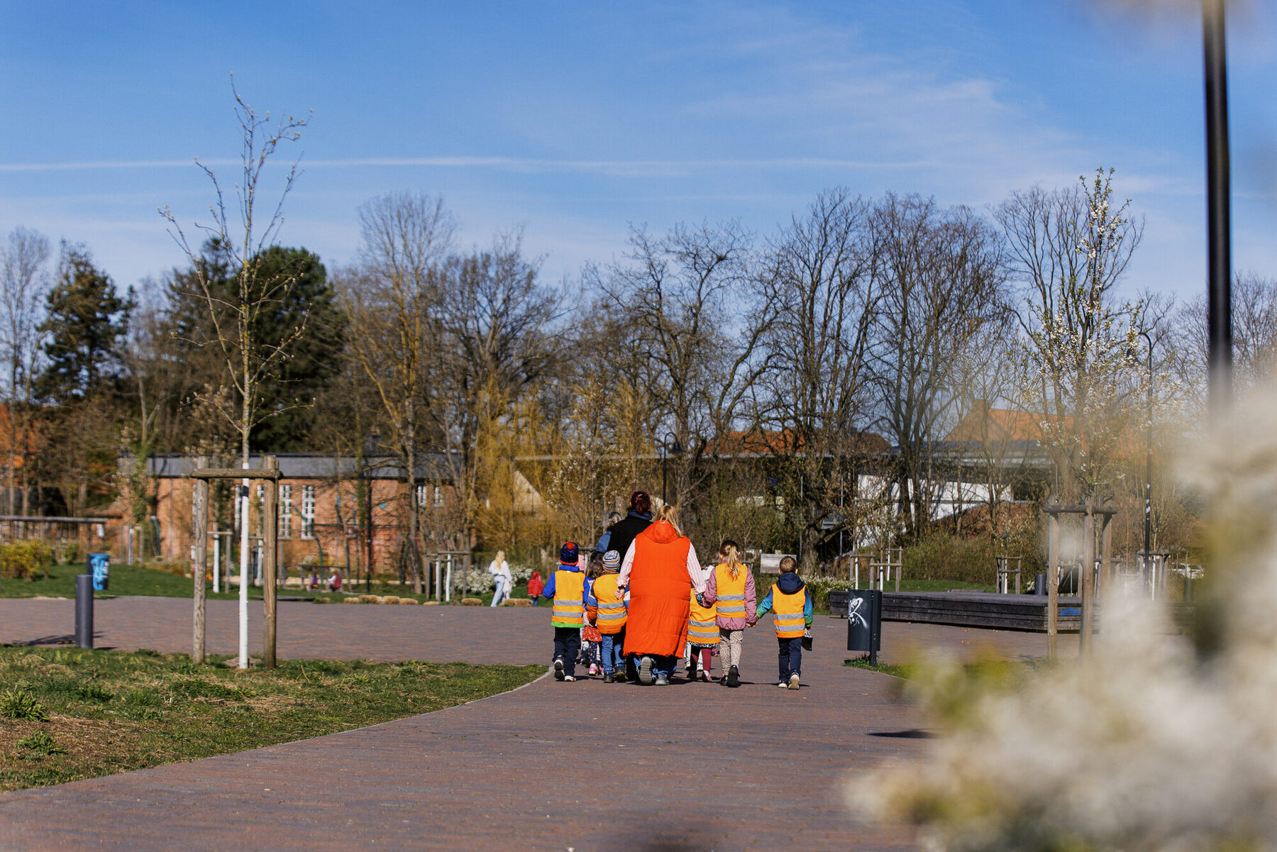 Ein breiter Weg führt durch eine kleine Grünanlage in Tostedt